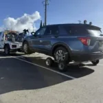A Bill's Towing truck towing a Ford Explorer SUV using rear wheel dollies to protect the transmission.